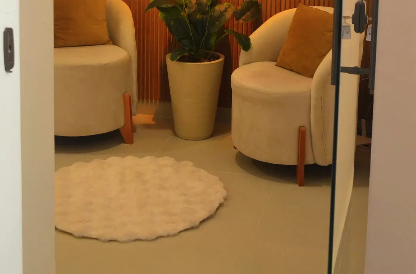 A calm clinic waiting area with armchairs and a plant